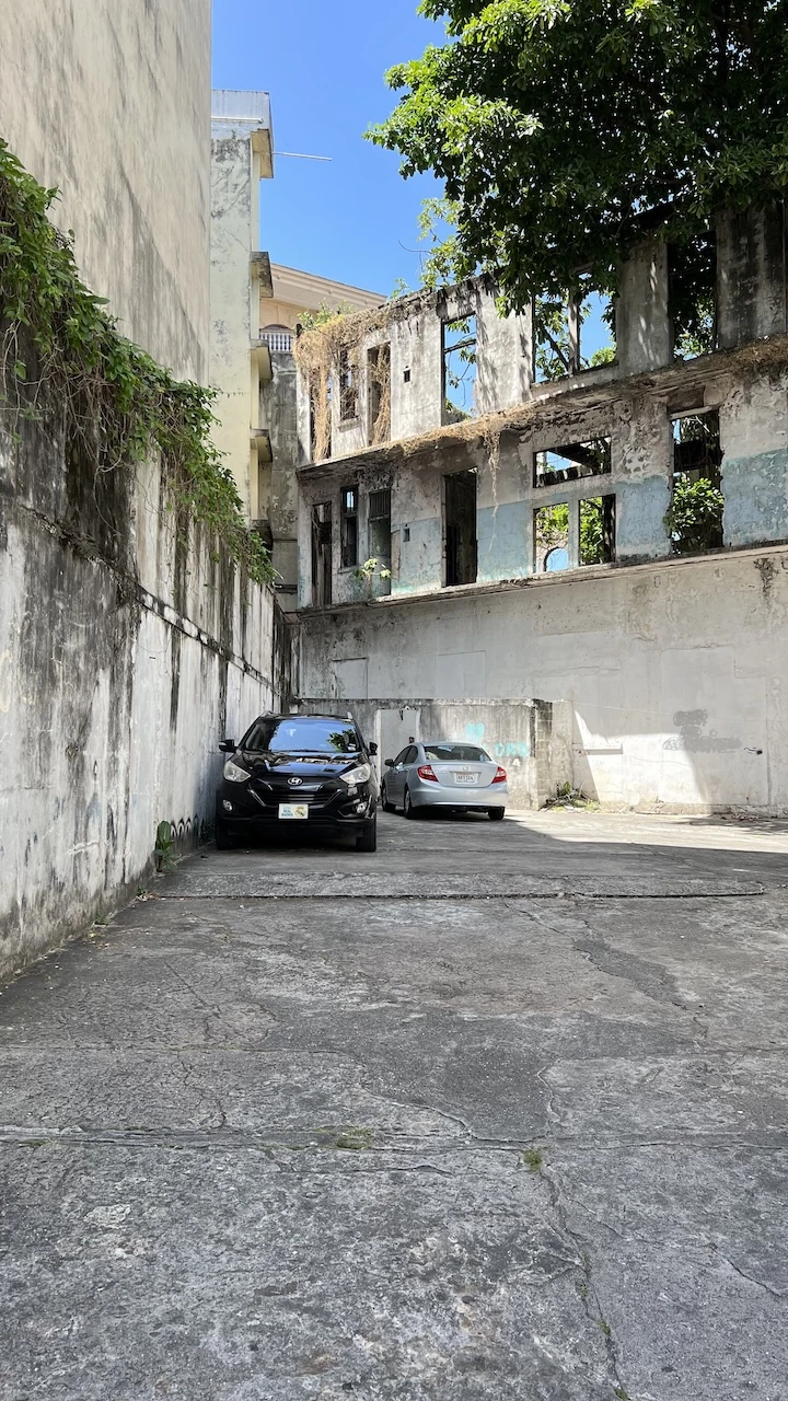 Hausruine davor zwei neuwertige Autos